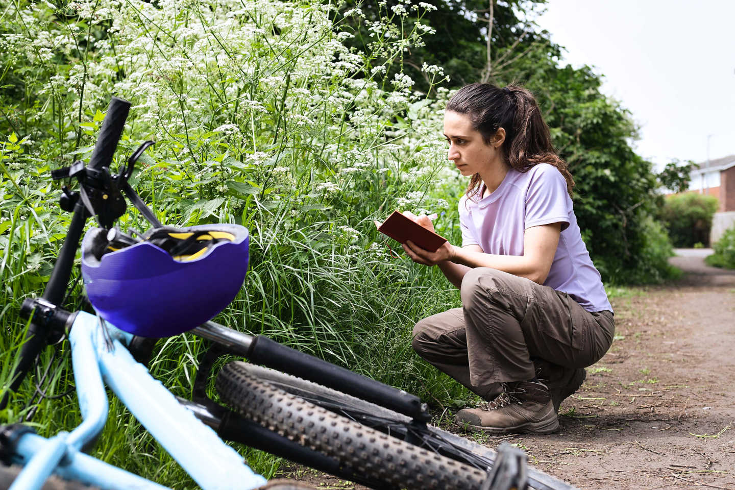 Frau mit umgekippten Fahrrad in der Natur