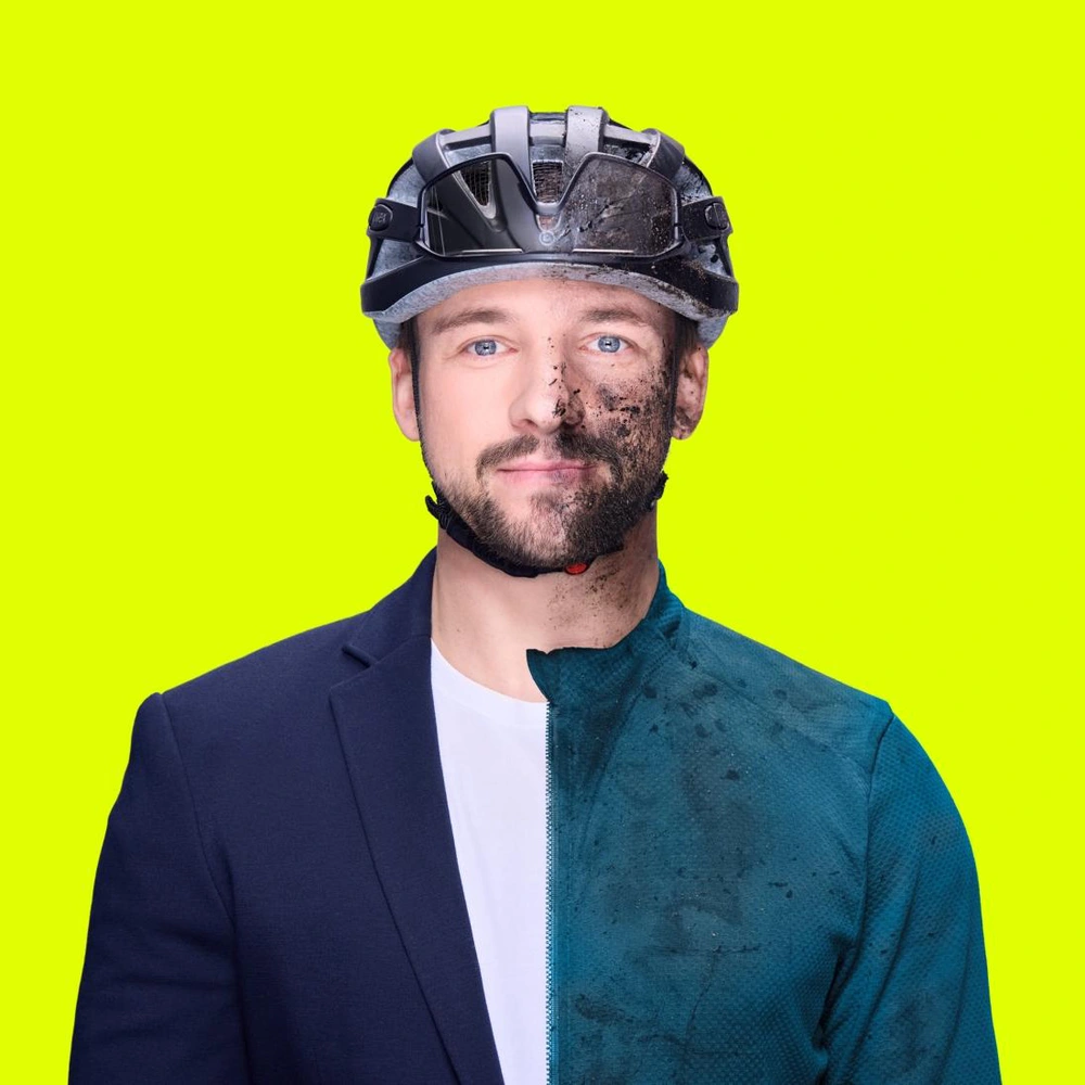 Mann mit Helm, gepflegter Anzug auf der einen, schmutziger Look auf der anderen Seite.